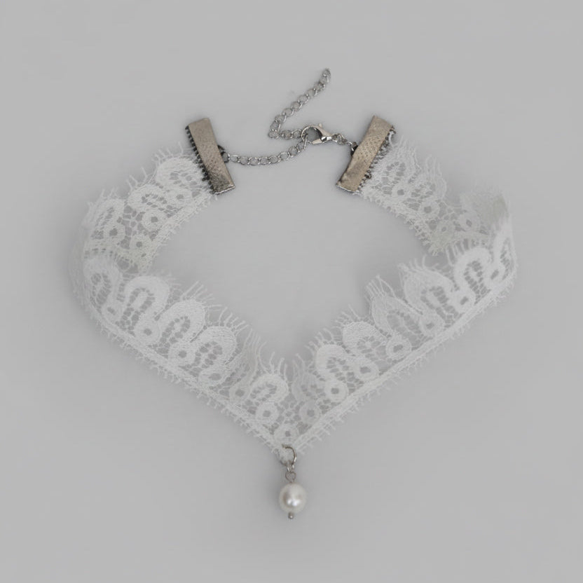 Lace choker necklace with a pearl pendant on a light gray background